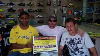 Marcelo Leite ao centro, com Altair Cabeça(camisa amarela) e Gerson Castro, na loja G Sportes com o cartaz do grande jogo.